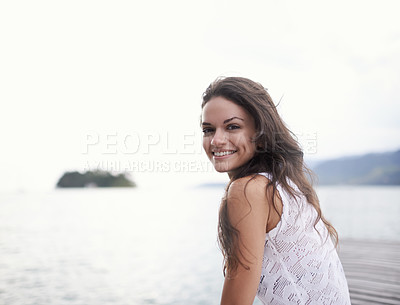 Buy stock photo Portrait of an attractive young woman sitting on a jetty by the lake
