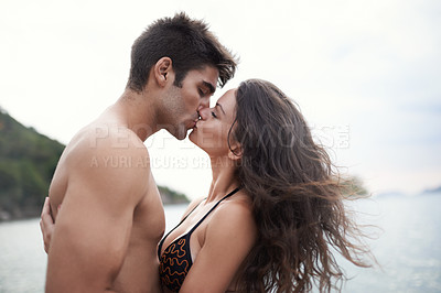 Buy stock photo Couple, kiss and travel to ocean on vacation, romance and relax by water on summer holiday. People, swimwear and bonding for relationship in outdoor, support and love on weekend trip to sea or nature