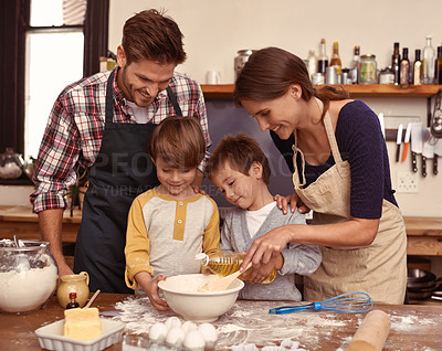 Buy stock photo Two cute little boys baking with their parents in the kitchen