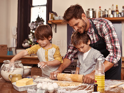 Buy stock photo Two cute little boys baking with their father in the kitchen