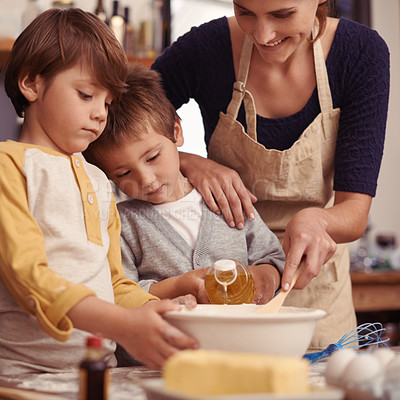 Buy stock photo Two cute little boys baking with their mother in the kitchen
