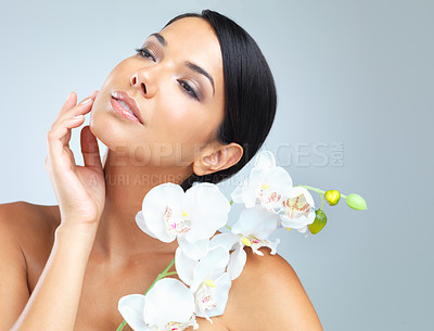 Buy stock photo Flowers, skincare and woman with beauty, wellness and person on grey studio background. Model, luxury and girl with aesthetic and cosmetics with facial or shine with glow, dermatology and smooth skin
