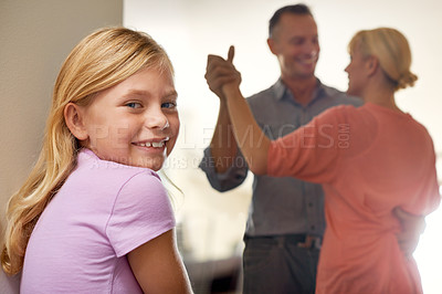 Buy stock photo Girl, portrait and smile while parents dance in home, childhood and happy on weekend. Female person, happy couple and love or bonding for fun, smile and calm mindset to relax or confident in joy