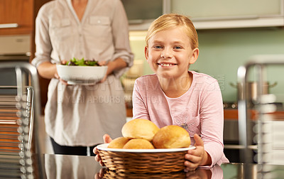Buy stock photo Girl, portrait and cooking in kitchen with mother, meal and learning for child development in home. Daughter, mommy and food preparation with bread basket for lunch, nutrition and smile for baking