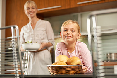 Buy stock photo Portrait, girl and mother with cooking in kitchen, home and wheat rolls with salad for healthy food. Happy family, face or satisfaction for dinner or nutrition or bonding together on holiday in house