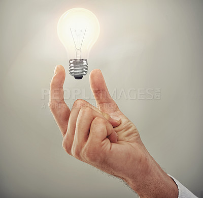 Buy stock photo Hand, light bulb glow and ideas for business growth and development isolated on grey background. Person with insights, corporate innovation and knowledge for enlightenment and inspiration in studio