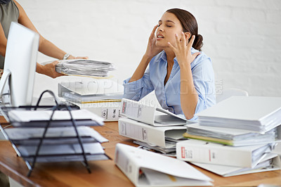 Buy stock photo A young businesswoman looking frustrated as she's handed more paperwork