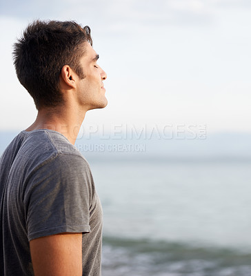 Buy stock photo Cropped shot of a handsome young man on the beach