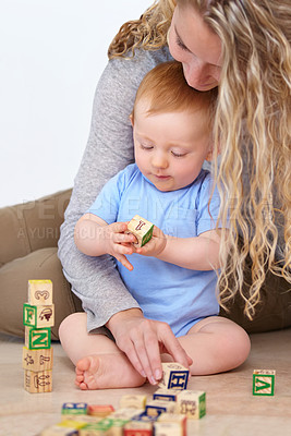 Buy stock photo Mother, baby and playing with wooden blocks or toys for childhood development or bonding at home. Mom, toddler and little boy learning shapes, letters or building together for fun activity at house