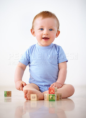 Buy stock photo Happy, baby with toy blocks and playing against a white background with smile. Child development or learning, happiness or health wellness and boy toddler play against a studio backdrop on floor