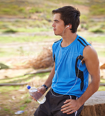 Buy stock photo Athlete, rest and drinking water on run outdoor, running and music while exercising. Nature, forest and workout with bottle for hydration, earphones and motivation or training for trail marathon 