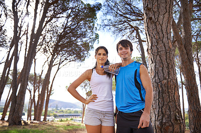 Buy stock photo Fitness, couple and healthy water in forest, smile on nature hike and athlete wellness. Summer, exercise and sports for marathon runner, conservation and environment in park for workout portrait