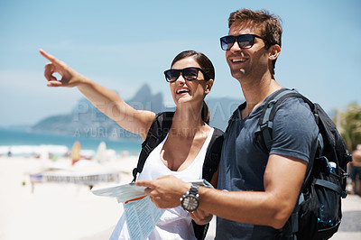 Buy stock photo Couple, map and pointing by beach on holiday, smile and excited with search for direction. Woman, man and chart for location, landmark and travel for memory on vacation, nature and thinking in Italy