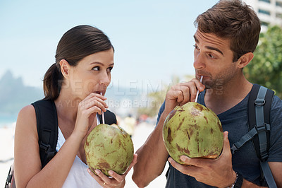 Buy stock photo Couple, coconut and drink at beach in summer for vacation with milk, cocktail and juice on journey. People, man and woman with thinking, review and fruit for water, hydration and detox with nutrition