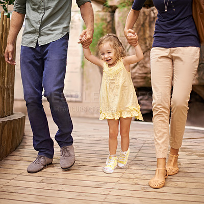 Buy stock photo Happy, little girl and holding hands with parents for bonding, adventure or field trip. Excited child or kid walking with mom and dad in travel for fun holiday, weekend or sightseeing together