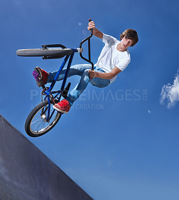 Buy stock photo Cropped shot of a teenage boy riding a bmx at a skatepark