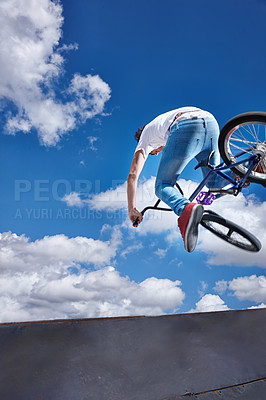 Buy stock photo Rearview shot of a teenage boy riding a BMX at a skatepark