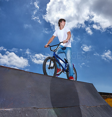 Buy stock photo Riding, bike and teen on ramp for sport performance or event at park in summer with blue sky mockup. Bicycle, stunt or kid balance on edge of board for trick in cycling competition or challenge