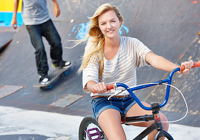 Buy stock photo Ride, bike and portrait of teenager at skatepark in summer with friends on vacation or holiday with adventure. Girl, relax and enjoy exercise on bicycle with a smile for sports, event or fun in city