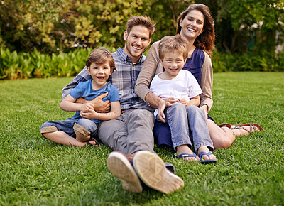 Buy stock photo Smile, nature and portrait of children with parents relaxing on grass in outdoor park or garden. Happy, love and boy kids sitting on lawn with mother and father for bonding in field together.