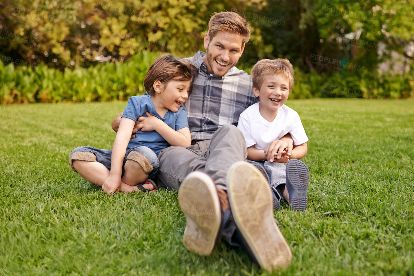 Buy stock photo Smile, nature and portrait of kids with father relaxing on grass in outdoor park or garden. Happy, family and excited boy children sitting on lawn with young dad for bonding in field together.