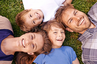 Buy stock photo Portrait of a loving family lying on the grass together