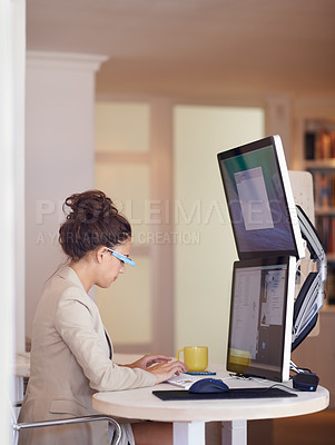Buy stock photo Shot of a young woman wearing smart glasses while working on a dual-screen computer. The commercial product(s) or designs displayed represent simulations of a real product, and are changed or altered enough so that they don't have any copyright infringements. Our team of retouching and design specialists custom designed these elements for each photo shoot