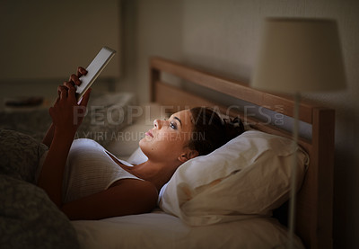 Buy stock photo Cropped shot of an attractive young woman using her tablet in bed