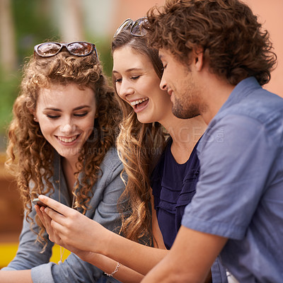 Buy stock photo Friends, laughing and talking with cellphone for social media, internet and text. Young people, conversation and humor with tech for online and scrolling for memes, comedy and laughter with app