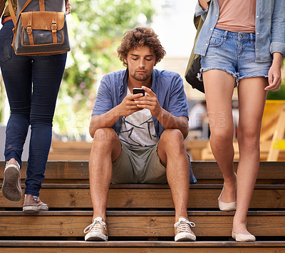 Buy stock photo Phone, school and student man on stairs of university or college campus for social media break. Education, scholarship and study with young person typing mobile text message on steps at recess