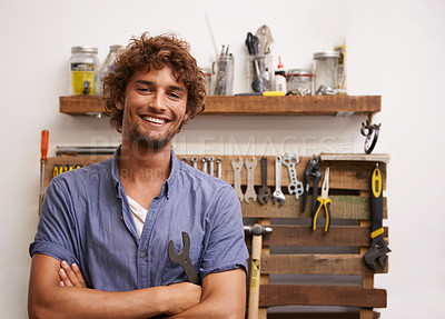 Buy stock photo A young man standing in front of his tools in the garage