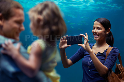 Buy stock photo Aquarium, woman or phone for photo, family or outing for fun, happy or bonding together in Brazil. People, smartphone and fish tank for social media, exploration and marine life on playful weekend