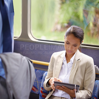 Buy stock photo Shot of a businesswoman using a digital tablet while commuting on a bus