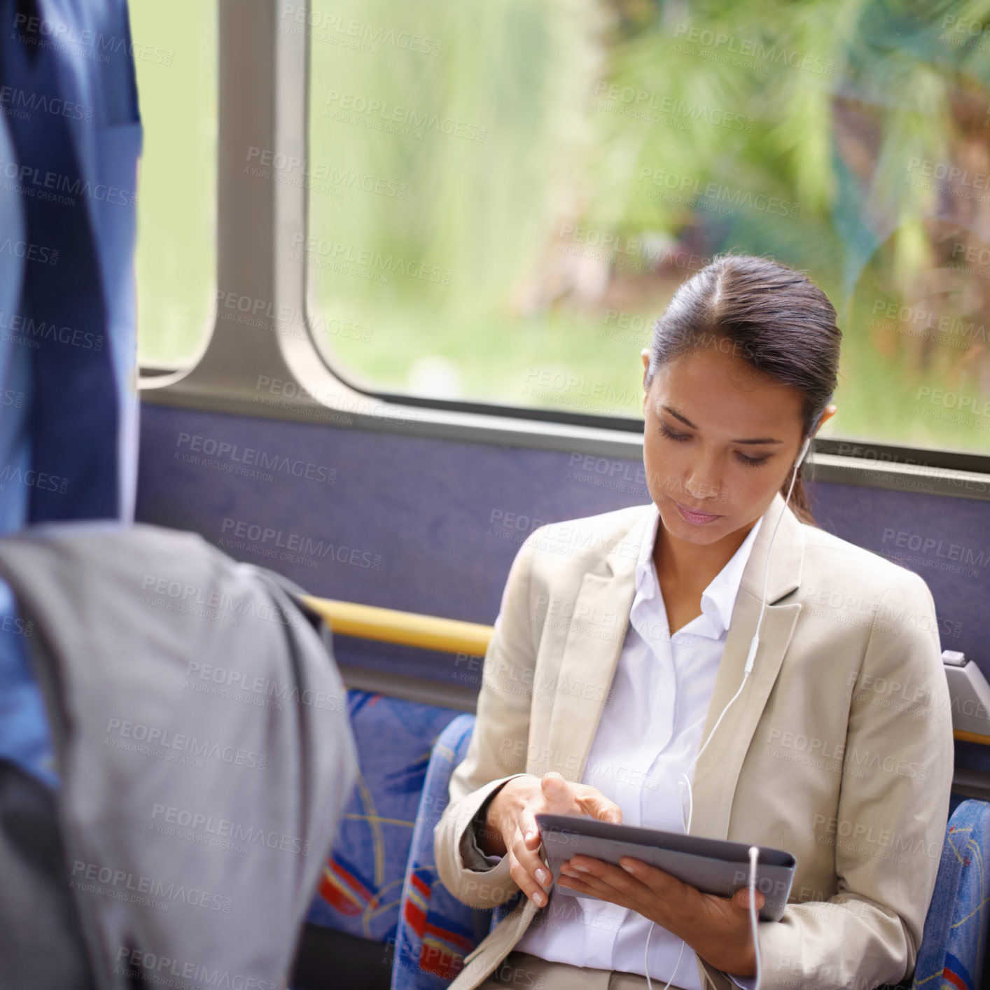 Buy stock photo Shot of a businesswoman using a digital tablet while commuting on a bus