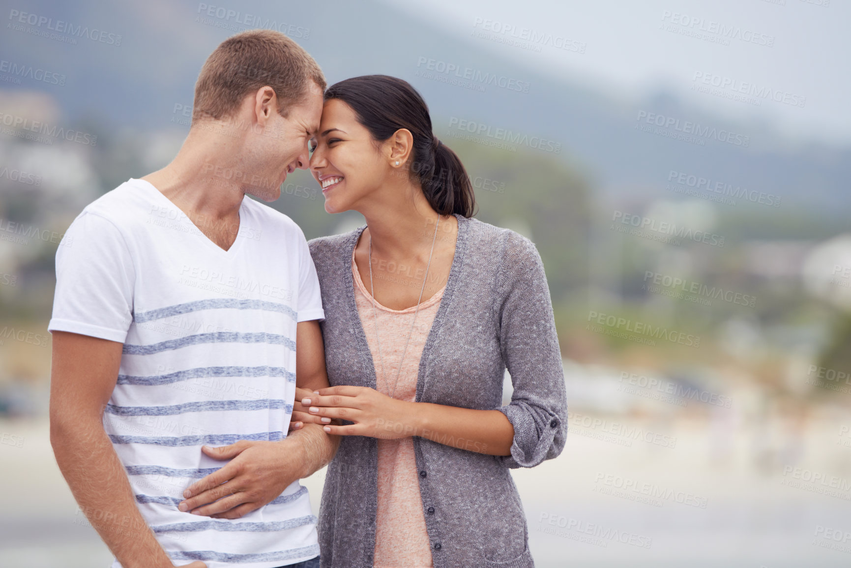 Buy stock photo Couple, hug and walking on the beach for travel, forehead touch and happiness together outdoor. Romantic adventure, love and affection for bonding, support and trust with commitment on holiday