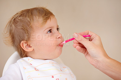 Buy stock photo Cropped shot of a baby being spoonfed