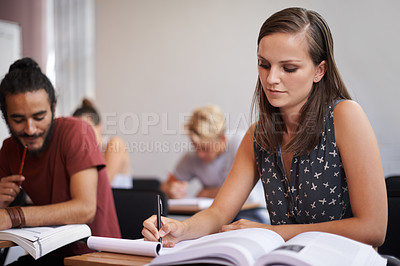 Buy stock photo Woman, student and writing in classroom for studying, reading or summary in book at university. Female person or academic writer taking notes for assignment, test or literature exam on desk at campus