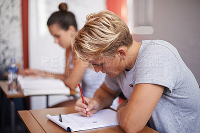 Buy stock photo Man, student and writing with book in classroom for studying, reading or summary at university. Male person or academic writer taking notes for assignment, test or literature exam on desk at campus