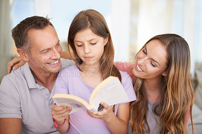 Buy stock photo Father, girl and mom with book on sofa for hug, care or connection in family home for reading. Dad, mother and daughter on couch together with teaching, education or embrace for storytelling in house