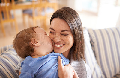 Buy stock photo Mother, baby and kiss for love in embrace, care and support or relax in living room and comfortable. Mommy, son and affection for bonding in childhood, security and happiness in hug or smile on face