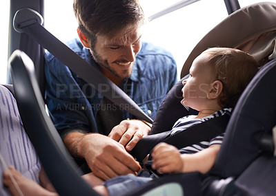 Buy stock photo A young father strapping his baby into a car seat