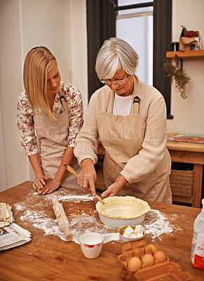 Buy stock photo Shot of a grandmother teaching her granddaughter how to bake