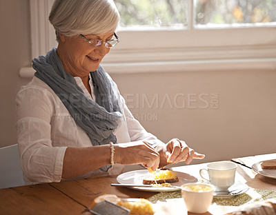 Buy stock photo Senior, woman and eating breakfast in home with bread, cheese and tea with happiness by table in the morning. Elderly, person and smile with lunch, snack or food for nutrition and meal in dining room