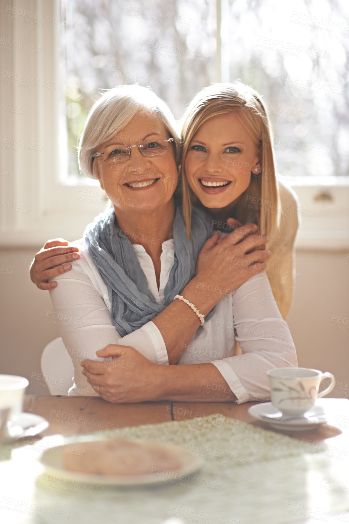 Buy stock photo House, hug and girl visit mom for breakfast, coffee and daughter with senior, retirement and embrace. Female person, smile and happiness with mother in family home, elderly and woman in dining room