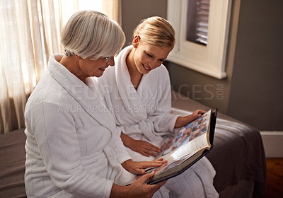 Buy stock photo Grandmother, woman and hospitality at home, hotel and happy for bonding and looking at photo album memories. Senior lady, daughter and moment for self care, robe and bedroom for comfort and spa day 