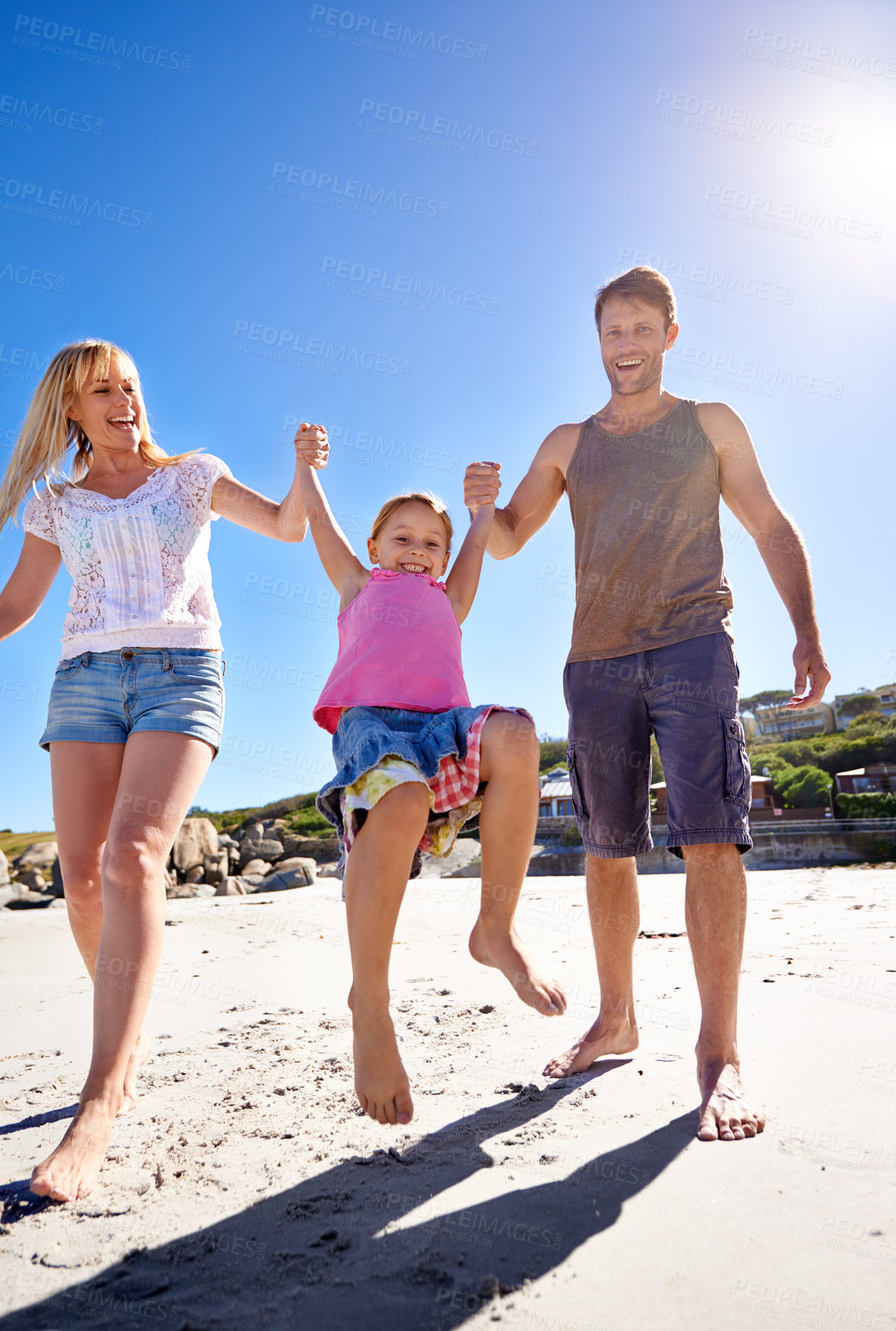 Buy stock photo Parents, swing and holding hands with girl at beach in portrait with care, love or bonding in summer on holiday. Father, mother and daughter with games, connection or playing in sunshine on vacation