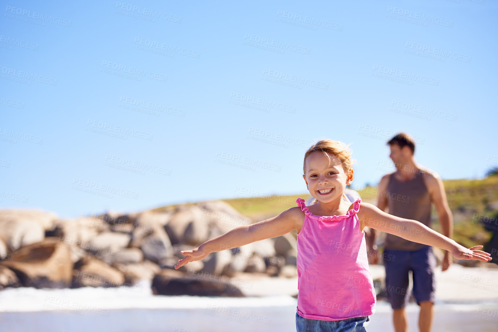 Buy stock photo Happy, portrait and little girl flying on beach with blue sky for fun summer, holiday or outdoor weekend in nature. Female person, child or kid with smile for playful day by the ocean coast on mockup