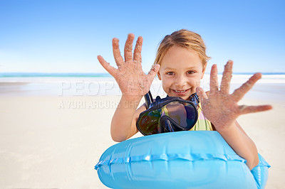 Buy stock photo Girl, portrait and hands for swimming on sand, beach and goggles or inflatable donut on holiday. Female person, child and happy on tropical vacation in outdoors, ocean and blue sky for mockup space