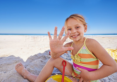 Buy stock photo A cute little girl sitting on the sand at the beach with her bucket and spade