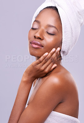 Buy stock photo Calm, black woman or hair towel in studio with skincare, wellness or beauty on purple background. Makeup, cleaning or hands on face of African female model touching soft, skin or cosmetic results